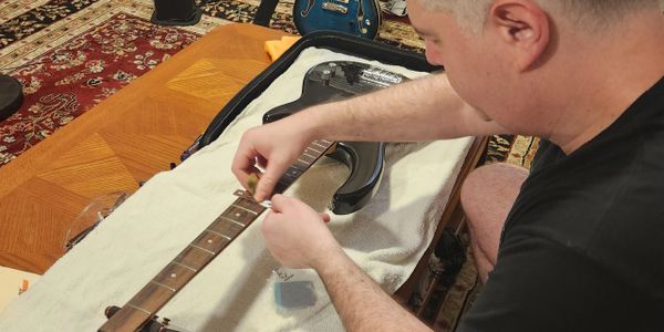 Our tech performing a setup on a bass guitar
