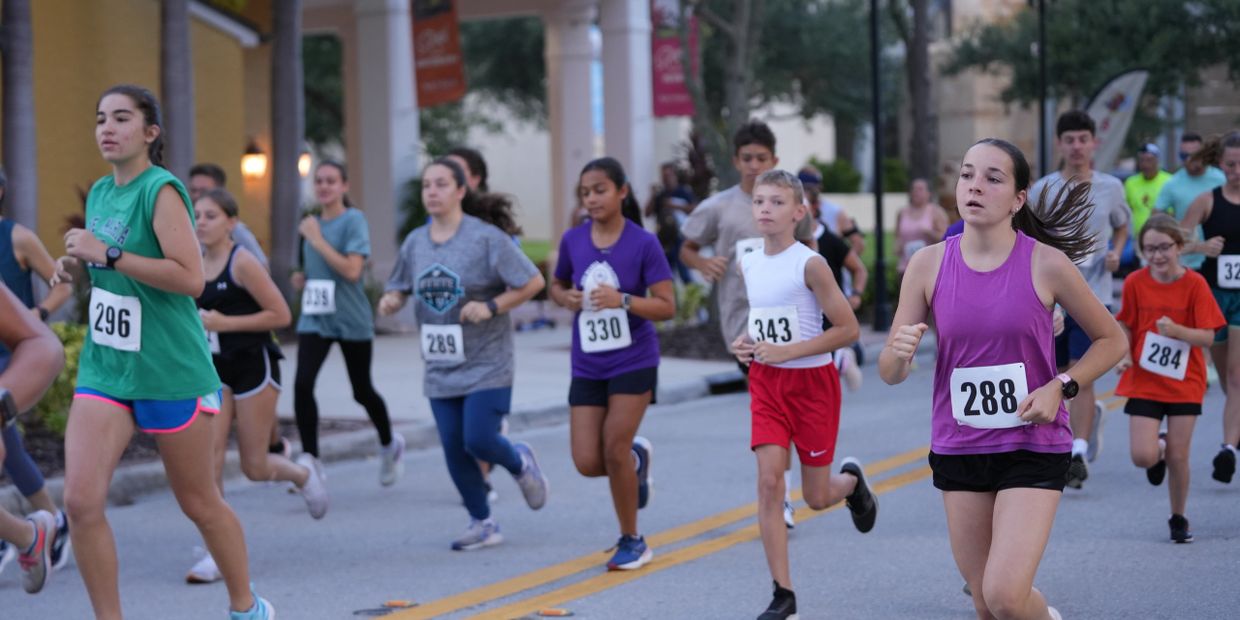 Young runners participating in a community race on a city street.