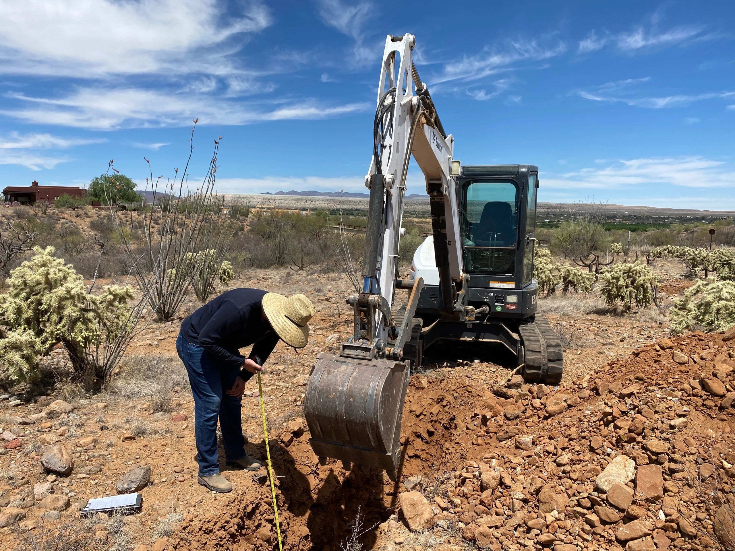 A civil engineer is measuring how deep the percolation test hole is. 