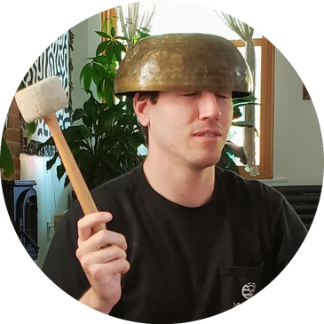 Metal singing bowl inverted on head of young man