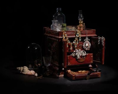 Vintage jewelry box with antique items and shells.