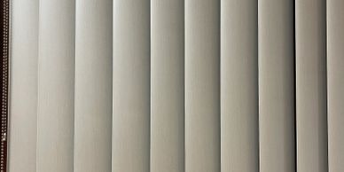 Vertical window blinds in a neutral color.