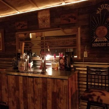 Cozy rustic bar setup with wooden decor and dim lighting.