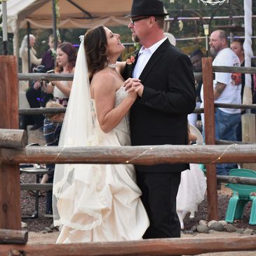 Bride and groom dancing closely at an outdoor wedding reception.