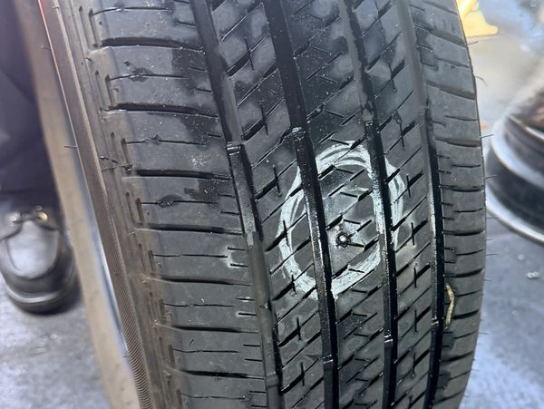 Car tire with a marked nail embedded in the tread.