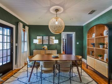 Cozy dining room with green walls and wooden furniture.
