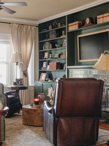 Cozy living room with leather armchairs and built-in bookshelves.