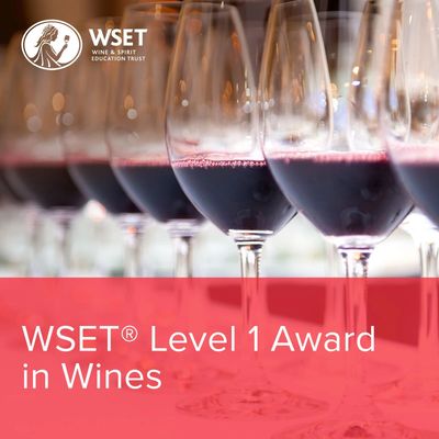 Close-up of red wine glasses with WSET Level 1 Award in Wines text.