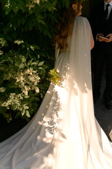Bride in a flowing white wedding dress holding flowers.
