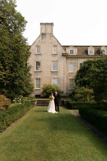 Bride and groom standing outside a historic building.
