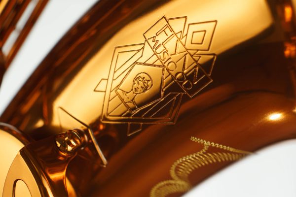 Close-up of a shiny brass instrument with engraved logo.