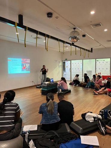Group attending a presentation in a spacious room with a projector screen.
