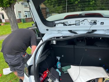 An electrician installing a car camera system