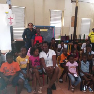 Group of children and adults gathered indoors, smiling and posing for a photo.