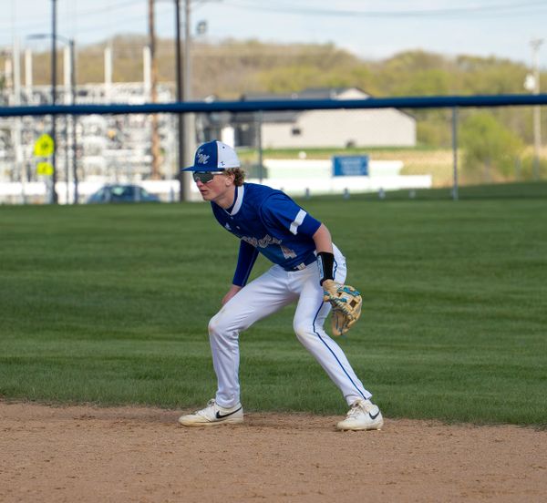 Young baseball player ready in fielding position during game.