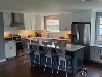 blue island cabinets, stainless refrigerator, slide in range and canopy hood and white cabinets