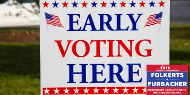 Sign indicating early voting with an election campaign ad attached.