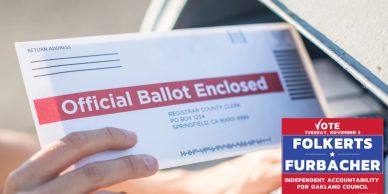 Hand placing an official mail-in ballot into a mailbox.