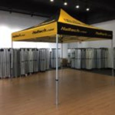 Yellow and black promotional canopy tent indoors on wooden floor.