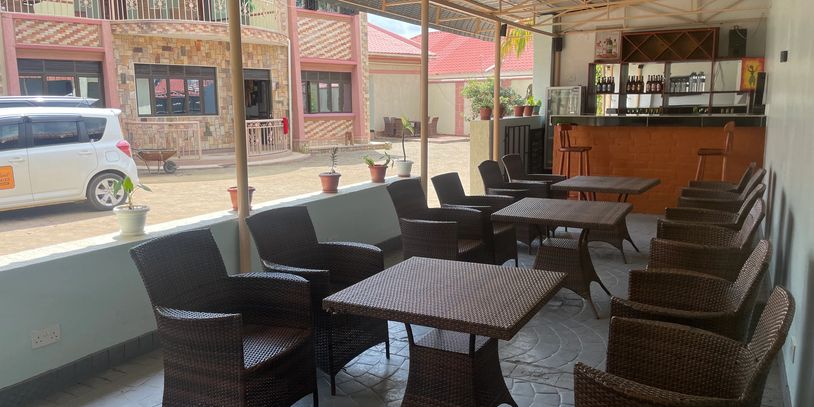 Outdoor seating area with wicker chairs and tables under a covered patio.