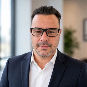 Professional man in glasses and suit posing indoors.