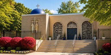 Church building with statues and a blue dome.