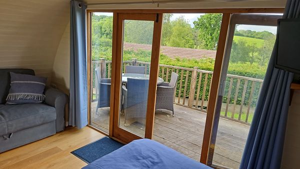 Riverside glamping pod near Builth Wells, Powys Wales with bed, sofa and deck access country views