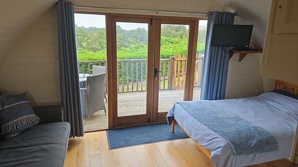 Riverside glamping pod near Builth Wells, Powys Wales with bed, sofa and deck access country views