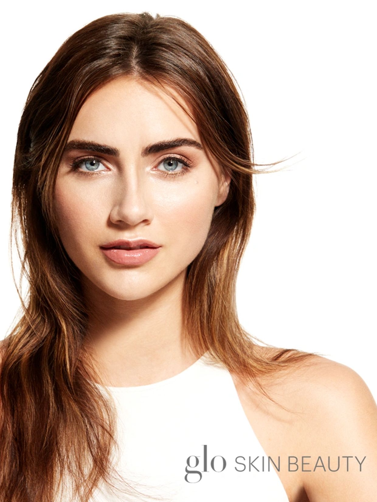 Close-up of a woman with flawless skin and blue eyes.