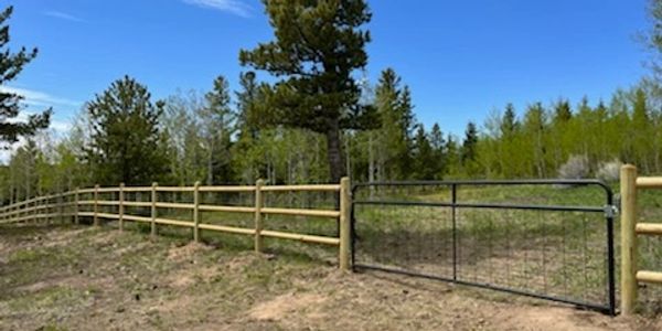 Three rail post and dowel fence with gate in Nederland Colorado 