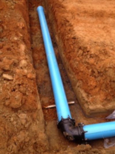 Long blue pipe in an excavated trench.
