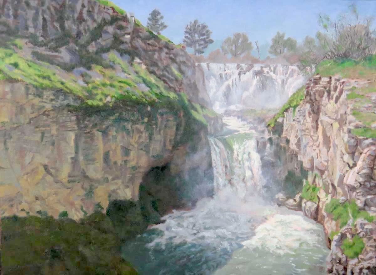 A serene waterfall cascades between rocky cliffs with greenery.