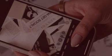 Person holding phone, capturing photo of scattered papers.
