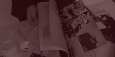 Hand flipping through a magazine with various articles and images.