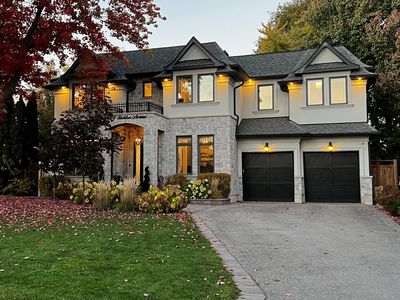 Front view of a detached home for sale in Oakville with manicured landscaping and double garage

