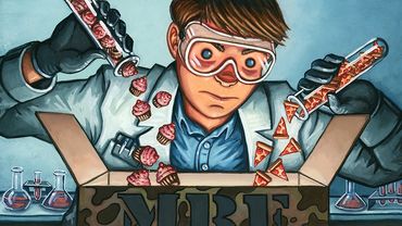 A scientist adding pouring tiny pizza and cupcakes into a box labeled MRE