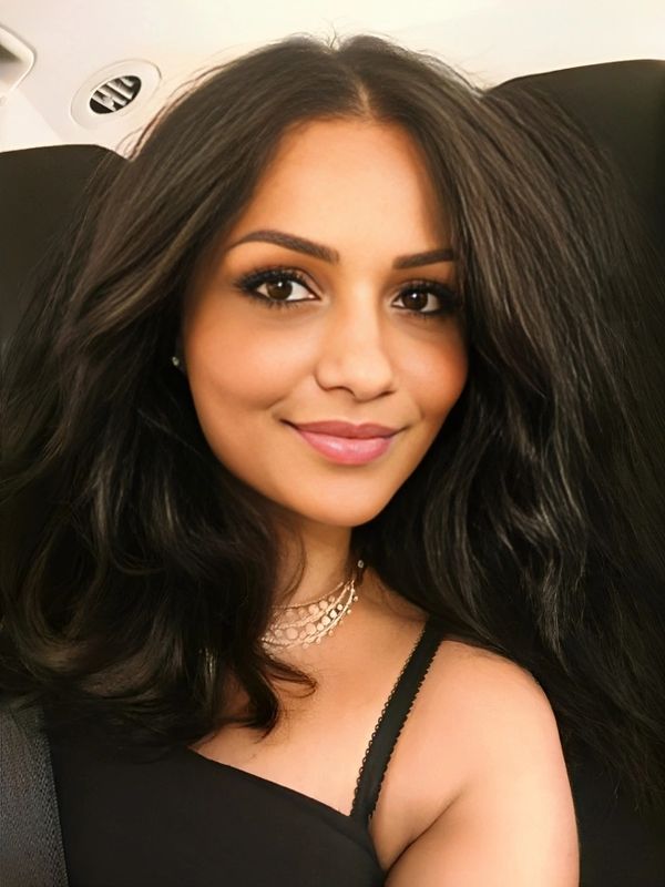 Smiling woman with voluminous dark hair.