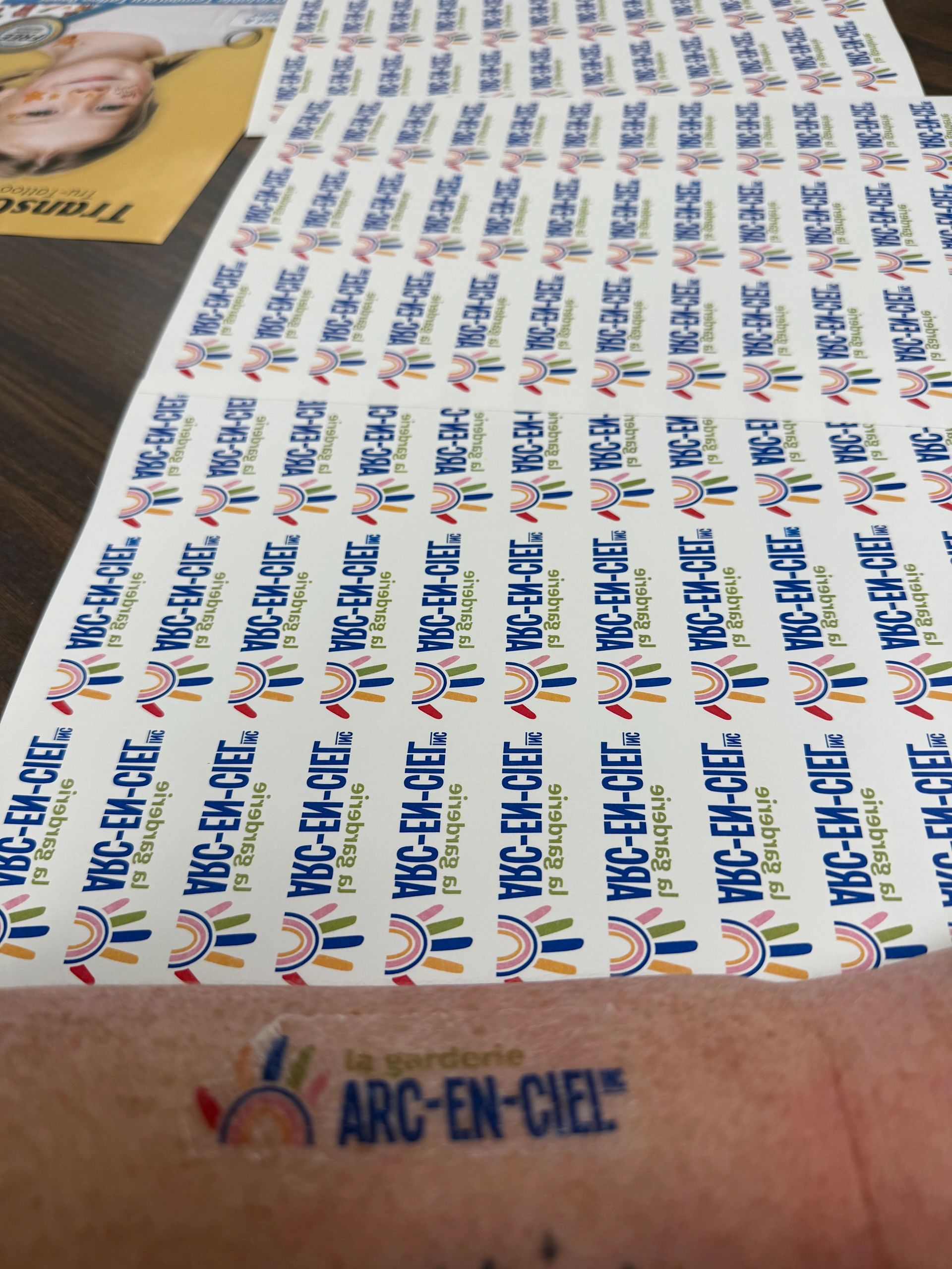Sheets of colorful Arc-En-Ciel labels on a table.