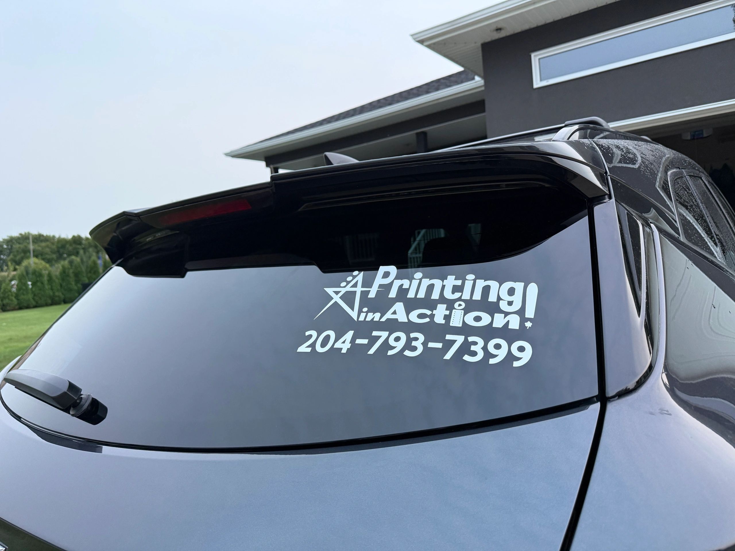 Car window with Printing in Action advertisement decal.