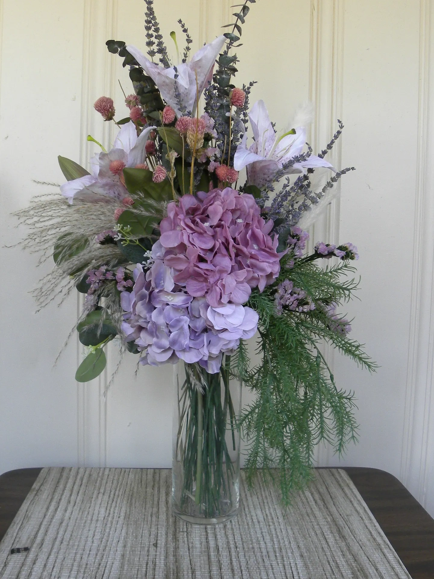 12 Tall glass vase, hydrangea, lily, mixed dried flowers and mixed greens.  Total height 28"  Starti