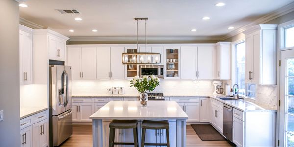 Bright modern kitchen with white cabinets, polished surfaces, and professional cleaning services.