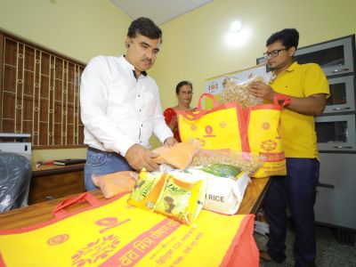 People packing food items into yellow bags indoors.
