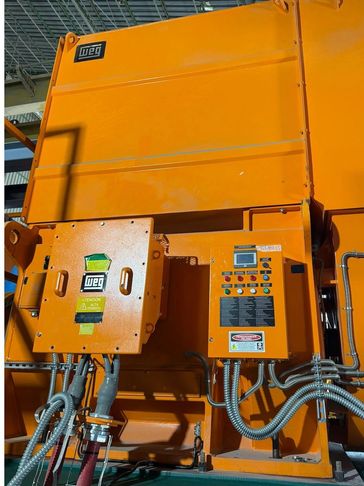 Bright orange industrial control panels with various buttons and cables.
