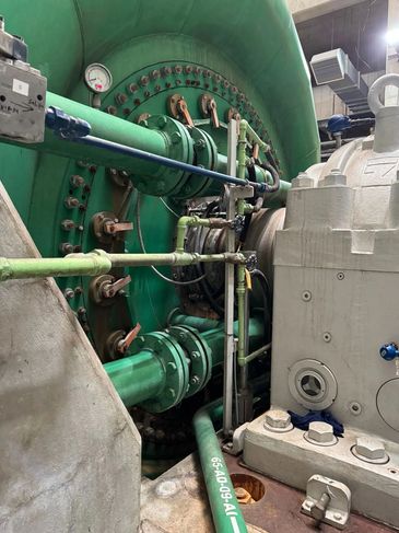 Large industrial machine with green pipes and gauges.