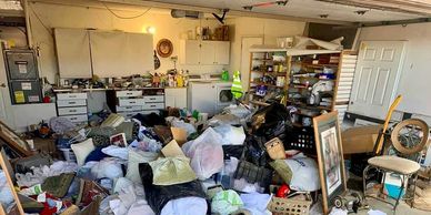 Cluttered garage with piles of bags and miscellaneous items.