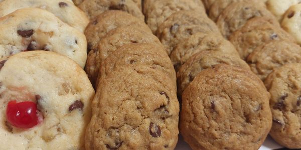 Assorted chocolate chip cookies, some with cherries.