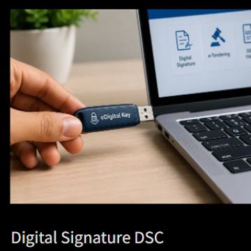 Hand holding a digital key USB near a laptop.