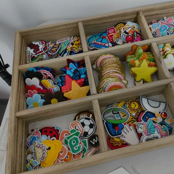 Wooden box with colorful embroidered patches in various shapes and designs.