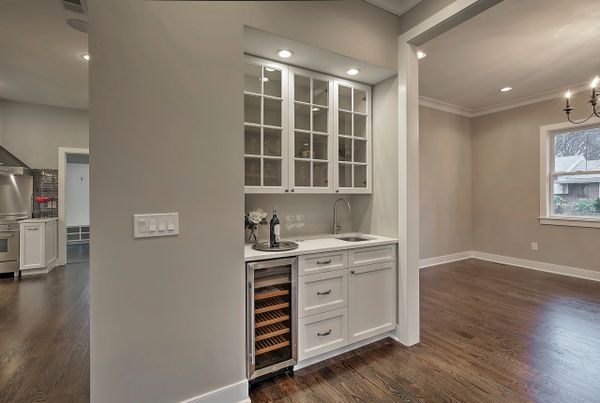 Elegant built-in wet bar with wine cooler and glass cabinets.