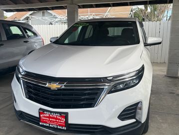 White Chevrolet SUV parked in a covered area with a black grille and sleek headlights.